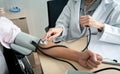 Doctor using sphygmomanometer checking blood pressure Royalty Free Stock Photo