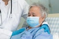 Doctor using stethoscope to checking Asian senior or elderly old lady woman patient wearing a face mask in hospital Royalty Free Stock Photo