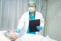 Doctor using stethoscope to checking Asian senior or elderly old lady woman patient wearing a face mask in hospital for protect Royalty Free Stock Photo