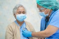 Doctor using stethoscope to checking Asian senior or elderly old lady woman patient wearing a face mask in hospital for protect Royalty Free Stock Photo