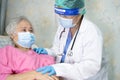 Doctor using stethoscope to checking Asian senior or elderly old lady woman patient wearing a face mask in hospital for protect Royalty Free Stock Photo