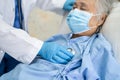 Doctor using stethoscope to checking Asian senior or elderly old lady woman patient wearing a face mask in hospital for protect Royalty Free Stock Photo