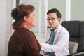 Doctor using stethoscope to exam woman patient heart.