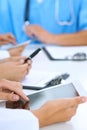 Doctor using tablet computer at medical meeting, closeup. Group of colleagues at the background Royalty Free Stock Photo