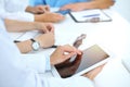 Doctor using tablet computer at medical meeting, closeup. Group of colleagues at the background Royalty Free Stock Photo