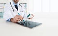 Doctor using tablet on desk office prescribes the medicine Royalty Free Stock Photo