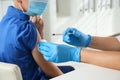 Doctor vaccinating little boy in hospital, closeup. Health care