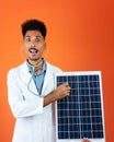 Doctor or Veterinarian Isolated on Orange Background. Black Young Doctor Medical Resident With Stethoscope Holding Solar Panel Royalty Free Stock Photo