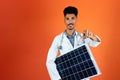 Doctor or Veterinarian Isolated on Orange Background. Black Young Doctor Medical Resident With Stethoscope Holding Solar Panel Royalty Free Stock Photo