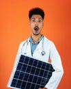 Doctor or Veterinarian Isolated on Orange Background. Black Young Doctor Medical Resident With Stethoscope Holding Solar Panel Royalty Free Stock Photo