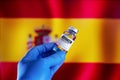 Doctor with a vial with doses of the vaccine in front of the Spanish flag