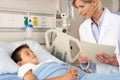 Doctor Visiting Child Patient On Ward Royalty Free Stock Photo