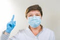 Coronavirus epidemic. Doctor warns of danger in the face of a pandemic. Portrait of a female doctor in a medical mask Royalty Free Stock Photo