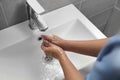 Doctor washing hands with water from tap in bathroom, above view Royalty Free Stock Photo
