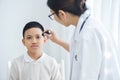 Doctor wear glasses checking a little boy patient eyes. Royalty Free Stock Photo