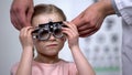 Doctor wearing at adorable child eye testing glasses to diagnose vision problems Royalty Free Stock Photo