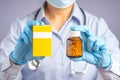 A doctor wearing a face mask and holding a pill bottle and pills box while standing in the hospital. Healthcare and medical Royalty Free Stock Photo