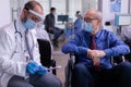 Doctor wearing face mask against coronavirus infection talking with disabled man Royalty Free Stock Photo