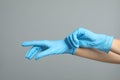 Doctor wearing medical gloves on grey background, closeup Royalty Free Stock Photo