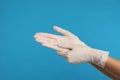 Doctor wearing medical gloves on light blue background, closeup Royalty Free Stock Photo