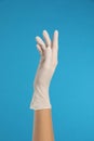 Doctor wearing medical gloves on blue background, closeup Royalty Free Stock Photo