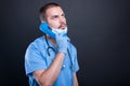 Doctor wearing scrubs holding telephone receiver Royalty Free Stock Photo