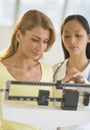 Doctor Weighing Woman On Balance Weight Scale