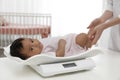 Doctor weighting African-American baby on scales Royalty Free Stock Photo