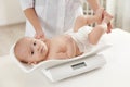 Doctor weighting baby on scales