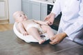 Doctor weighting cute baby at home Royalty Free Stock Photo