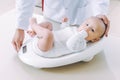 Doctor weighting cute baby at home Royalty Free Stock Photo