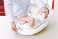 Doctor weighting cute baby at home Royalty Free Stock Photo