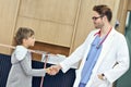Doctor welcoming young boy in clinic