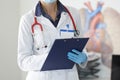 Doctor in white coat hold folder and write in office. Royalty Free Stock Photo