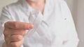 Doctor in white coat holds white ribbon. Concept lung cancer awareness. Bone cancer.