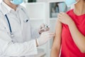 a doctor in a white coat makes an injection into the patient& x27;s arm vaccination Royalty Free Stock Photo