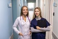 Doctor In White Coat And Nurse In Scrubs Looking At Digital Tablet In Hospital Corridor Royalty Free Stock Photo