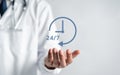 Doctor in a white coat uniform holding 24 7 service icon for assistance patient when accident or emergency, Medical call center Royalty Free Stock Photo