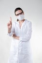 doctor in a white coat and wearing a protective mask and glasses makes a warning gesture. Royalty Free Stock Photo