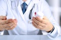 Doctor in a white labcoat choosing medicament between two drug packagings