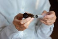 Doctor in a white surgical gown and blue mask holds in hands a medical syringe and bottle with medicine for injection. Insulin