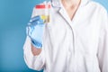 Doctor in white uniform and blue medical gloves holding container for urine analysis. Urine testing for diseases