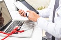 A doctor whose face is not recognized uses a tablet with his hands with his laptop and his stethoscope in his office. Technology