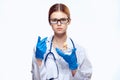 Doctor woman in blue gloves with stethoscope nurse with glasses injection syringe laboratory light background