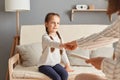 Doctor woman with clipboard talking small girl at psychological therapy session holding hands support little patient making Royalty Free Stock Photo