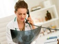 Doctor woman with fluorography talking phone