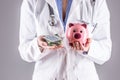 Doctor woman hands holding pills and piggy bank Royalty Free Stock Photo