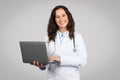 Doctor woman holding laptop with pleasant smile Royalty Free Stock Photo