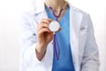 Unknown doctor woman holds stethoscope head, close-up. Physician ready to examine and help patient. Helping and