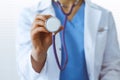 Unknown doctor woman holds stethoscope head, close-up. Physician ready to examine and help patient. Helping and